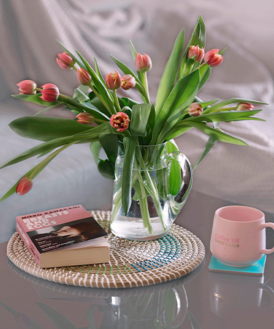 Tulipanes rosados en jarrón de vidrio sobre una mesa